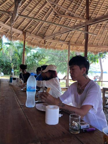 un groupe de personnes assises à une table en bois dans l'établissement The Last Point Koh Takiev, à Koh Ta Kiev