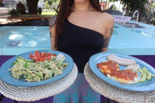 a woman is holding two plates of food at Casa Hala LOFT & SPA LUXURY in León