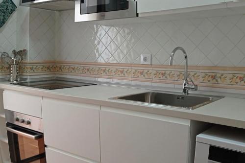 a kitchen counter with a sink and a stove at Casa Valencia by RentCadiz in El Puerto de Santa María