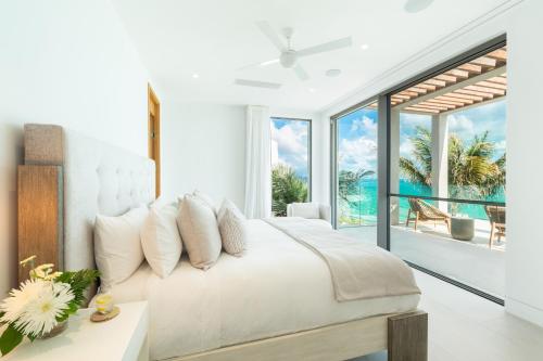 a bedroom with a white bed with a view of the ocean at South Bank in Long Bay Hills