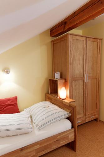 a bedroom with a bed and a wooden cabinet at Hildegard Naturhaus in Kirchberg bei Mattighofen