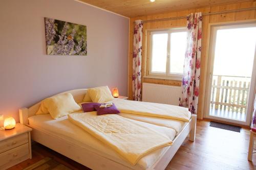 a bedroom with a large bed with two windows at Hildegard Naturhaus in Kirchberg bei Mattighofen