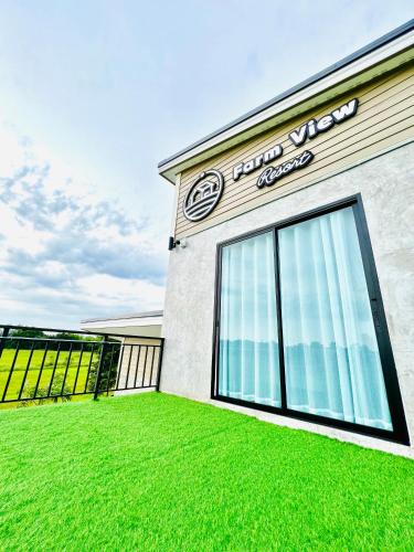 a building with a sign on the side of it at Farm View Resort @Uthai Thani ฟาร์มวิว รีสอร์ท อุทัยธานี in Nong Khayang