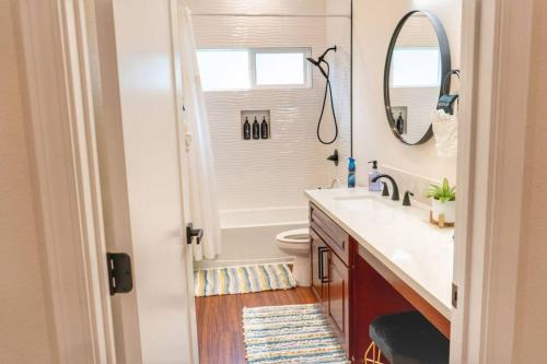a bathroom with a sink and a toilet and a mirror at Oceanfront Family Retreat - Views, A/C & Wi-Fi in Kaaawa