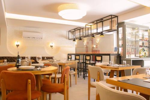 a restaurant with tables and chairs and a bar at Pousada Vila de Pedra in Jericoacoara