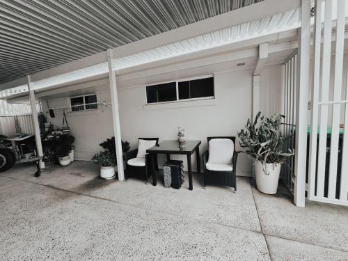 a patio with a table and chairs in a garage at Diggers Beach Villa Coffs Harbour in Coffs Harbour