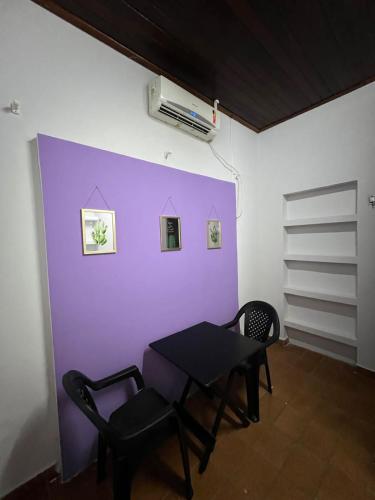Habitación con mesa, 2 sillas y pared púrpura. en Casa Jardim Guest House, en Carolina