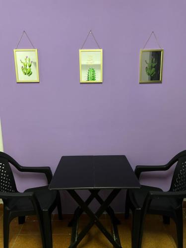 una mesa negra y dos sillas contra una pared púrpura en Casa Jardim Guest House, en Carolina