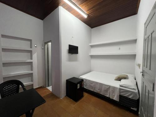 1 dormitorio con cama, silla y estanterías en Casa Jardim Guest House, en Carolina