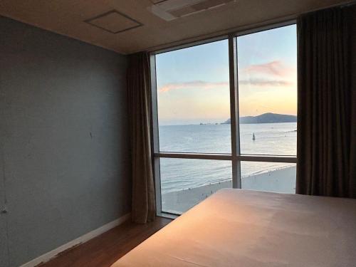 a room with a large window with a view of the ocean at Elysia Boutique Hotel in Busan