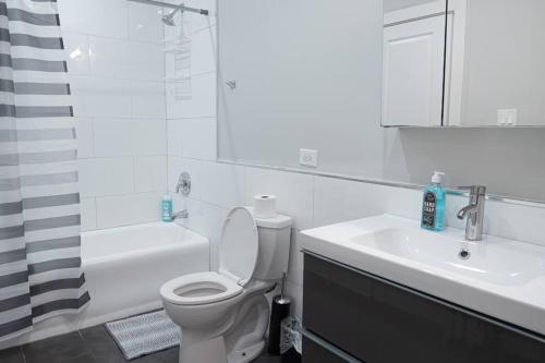 biała łazienka z toaletą i umywalką w obiekcie Charming 4BR unit in Historic Hyde Park near Beach w Chicago