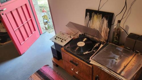 a room with a record player on a dresser with a red door at Casa rural junto al Río Chubut (Ty'r Bont) Trelew in Trelew
