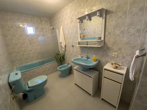 a bathroom with a blue toilet and a sink at -.Villa Nena 2.0.- in Ledesma