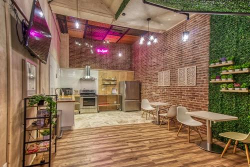 a kitchen with a brick wall and tables and chairs at Ram's Hotel in San Francisco