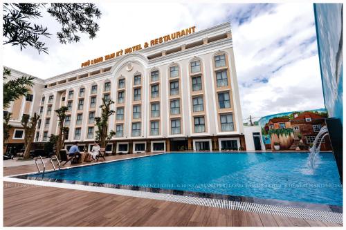a hotel with a swimming pool in front of a building at Phú Long Tam Kỳ Hotel & Restaurant in Tam Kỳ