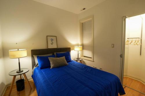 ein Schlafzimmer mit einem blauen Bett und zwei Lampen in der Unterkunft Modern 4BR in Hyde Park, Walk to University in Chicago