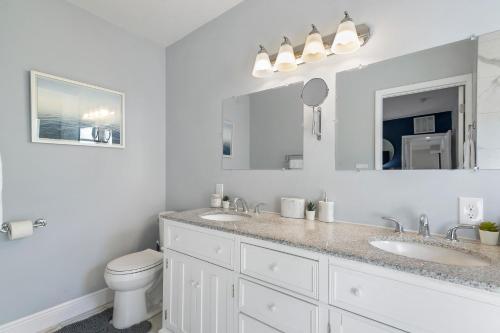 a white bathroom with two sinks and a toilet at Luxe 4br Escape Pet-friendly Outdoor Lounge in West Palm Beach