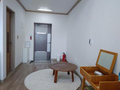 a room with a table and a chair and a mirror at Moon Forest Guesthouse in Jeju