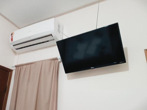 einen Flachbild-TV, der an einer Wand hängt in der Unterkunft Hotel e Lanchonete Bom Gosto in Bom Jesus da Lapa