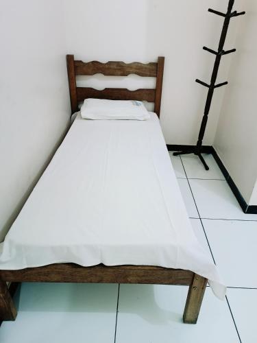 een klein bed in een kamer met witte muren bij Hotel e Lanchonete Bom Gosto in Bom Jesus da Lapa
