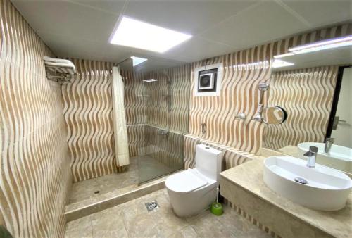 a bathroom with a toilet and a sink at SHH Hotel in Fujairah