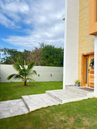 a white house with a palm tree in the yard at 5 Star Villa minutes from Airport and Beaches in Sosúa