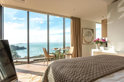 a bedroom with a bed and a view of the ocean at Omana in Rocky Bay