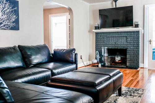 a living room with a leather couch and a fireplace at Peacefulprivateclassic Pet Friendlyocanoe Houz in Hampton