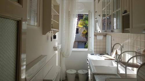 baño blanco con lavabo y ventana en Apartments by the sea Lovran, Opatija - 14180, en Lovran