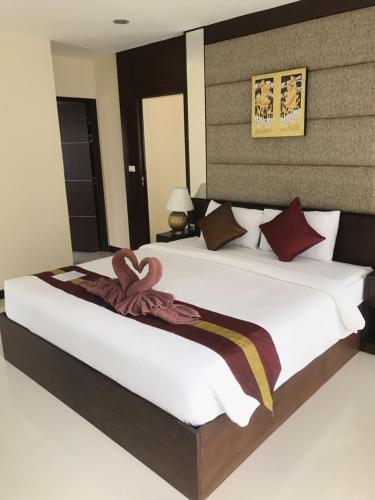 een slaapkamer met een groot wit bed met een bruin hoofdeinde bij The Lai Thai Luxury Condominiums- Sha Extra Plus in Ao Nang Beach