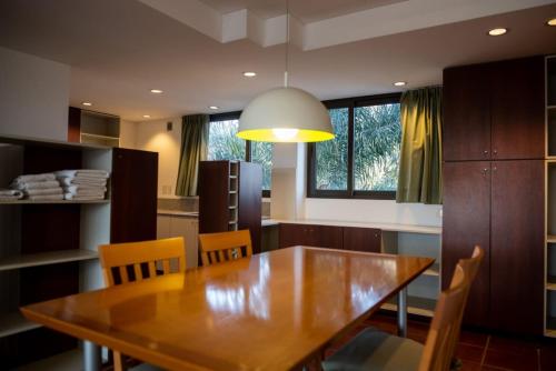 una sala da pranzo con tavolo e sedie in legno di Hotel boutique Tramas Andinas a Salta