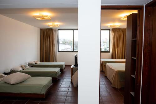 a hotel room with four beds in a row at Hotel boutique Tramas Andinas in Salta