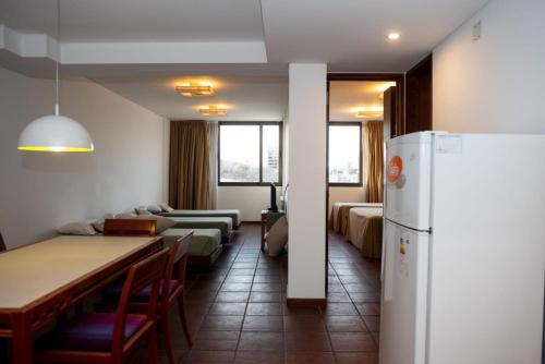 a room with a table and chairs and a refrigerator at Hotel boutique Tramas Andinas in Salta