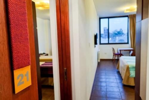 a hallway with a room with a bed and a window at Hotel boutique Tramas Andinas in Salta