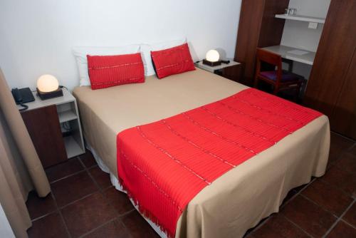 a bedroom with a large bed with red pillows at Hotel boutique Tramas Andinas in Salta