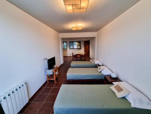 a room with four beds and a television at Hotel boutique Tramas Andinas in Salta