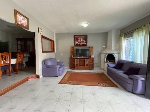 a living room with two purple couches and a tv at La Casa del Profe 