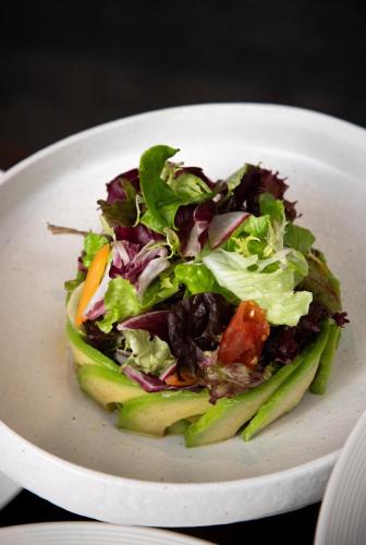 a salad in a white plate on a table at Artyzen NEW BUND 31 Shanghai Qiantan in Shanghai