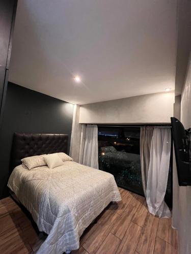 a bedroom with a bed and a large window at Edificio G4 in Guatemala