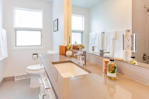 a white bathroom with a sink and a toilet at Bridger Hawk - Mid-Century Classic (NEW) in Bozeman