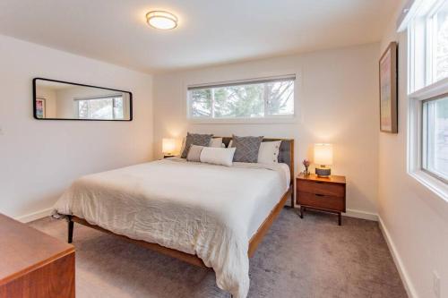 a bedroom with a large bed and two windows at Bridger Hawk - Mid-Century Classic (NEW) in Bozeman