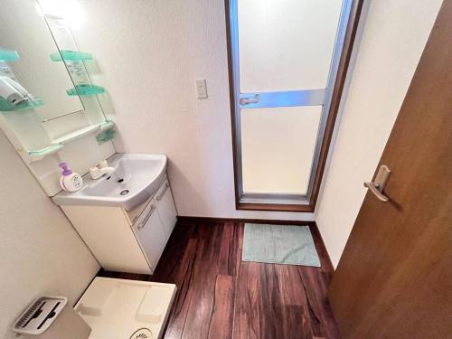 uma pequena casa de banho com um lavatório e um espelho em 日本橋電気街　DenDenTown大面積40㎡工レベ-タ-直結5F em Osaka
