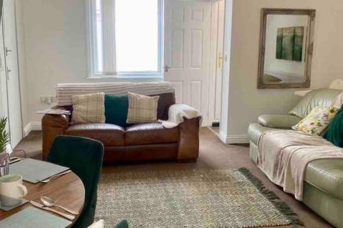 a living room with a couch and a table at WiFi Free Secure Parking Stadium & City Centre in Sunderland