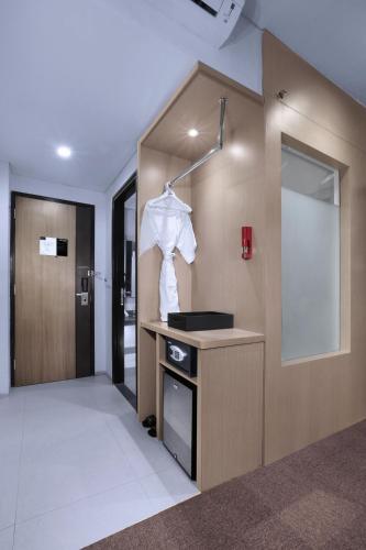 a room with a white shirt hanging on a wall at NEO+Waru-Sidoarjo by ASTON in Sidoarjo