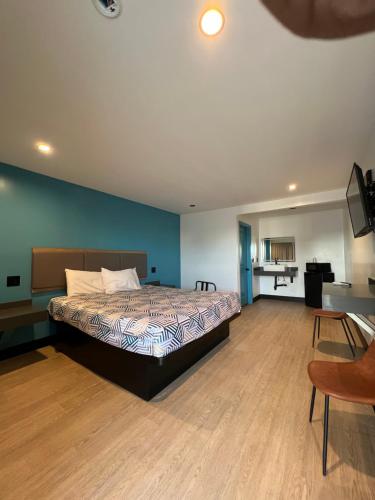 a bedroom with a bed and a television in it at Palm Inn Los Angeles NEW in Inglewood