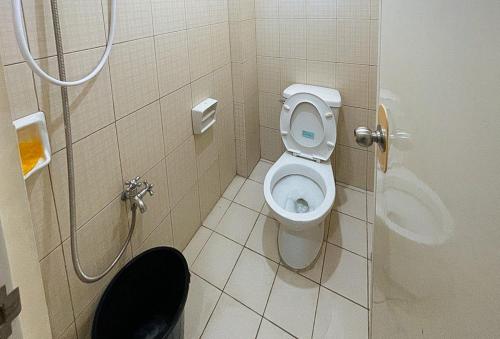 a bathroom with a toilet and a shower at RedDoorz @ Cion Suites Mintal Davao in Davao City
