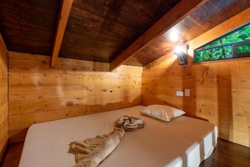um quarto com uma cama num quarto de madeira em Cabaña La Montaña: Vistas increíbles y Mirador em Turrialba