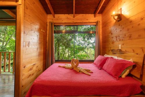 un animale di peluche su un letto in una stanza con finestra di Cabaña La Montaña: Vistas increíbles y Mirador a Turrialba