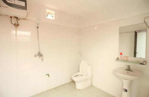 ein weißes Bad mit einem WC und einem Waschbecken in der Unterkunft Thái Sơn Homestay in Ha Giang