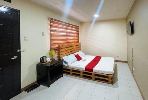 a bedroom with a bed with a wooden headboard at RedDoorz @ Cion Suites Mintal Davao in Davao City